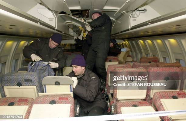 Police forensic officers inspect the interior of the Aghan Airlines Boeing 727 that was held at Stansted by hijackers for four days 11 February 2000....