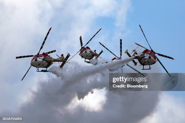 The Indian Air Force Sarang Aerobatic Team performs maneuvers during a flying display at the Singapore Airshow in Singapore, on Tuesday, Feb. 20,...
