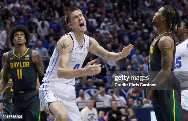 Noah Waterman of the Brigham Young Cougars reacts after dunking over Jalen Bridges and Jayden Nunn of the Baylor Bears during the second half of...