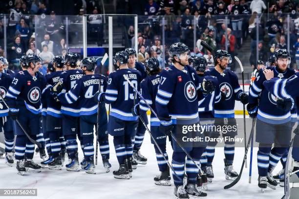 Winnipeg Jets players celebrate on the ice following a 6-3 victory over the Minnesota Wild at the Canada Life Centre on February 20, 2024 in...