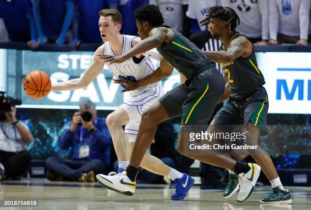 Spencer Johnson of the Brigham Young Cougars looks for a pass against Yves Missi and Jayden Nunn of the Baylor Bears during the first half of their...