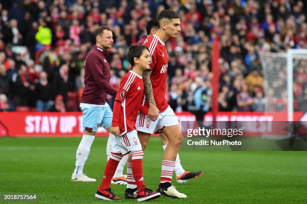 Nicolas Dominguez of Nottingham Forest is walking out with a match-day mascot during the Premier League match between Nottingham Forest and West Ham...