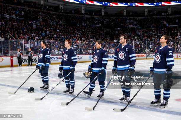Brenden Dillon, Mason Appleton, Neal Pionk, Adam Lowry and Nino Niederreiter of the Winnipeg Jets stands on the ice during the singing of the...