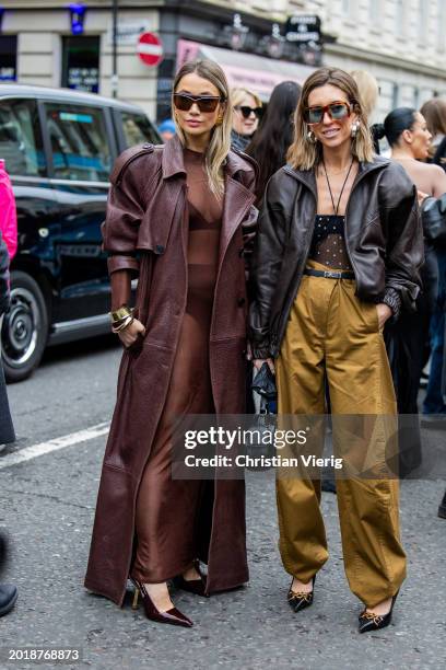 Nadia Phillips wears oversized brown coat, transparent dress, heels & Hannah Lewis wears brown leather jacket, light brown bag, bag, transparent top...
