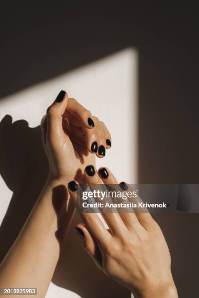manicure on female hands with black nail polish. - fingernagel stock-fotos und bilder