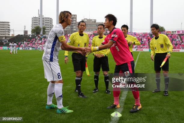 Captains Ryohei Arai of Ventforet Kofu and Yoichiro Kakitani of Cerezo Osaka shake hands at the coin toss prior to the J.League J1 match between...