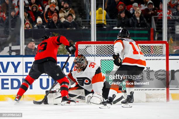 Samuel Ersson of the Philadelphia Flyers tends net against Nico Hischier of the New Jersey Devils during the first period during the 2024 Navy...