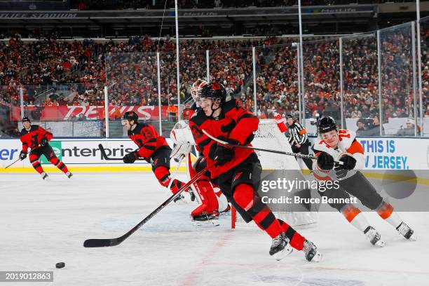 Luke Hughes of the New Jersey Devils is pursued by Owen Tippett of the Philadelphia Flyers during the first period during the 2024 Navy Federal...