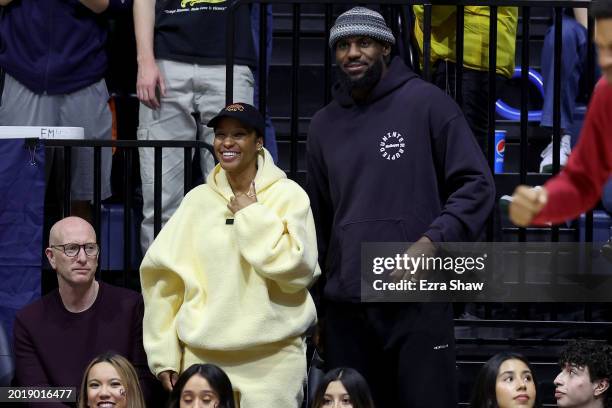 Lebron James of the Los Angeles Lakers, and his wife Savannah James, watch their son Bronny James of the USC Trojans play against the California...