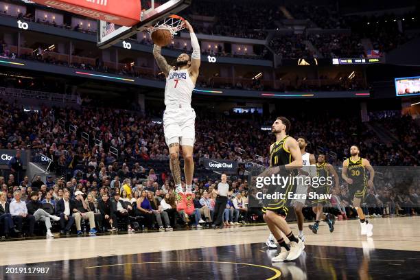 Amir Coffey of the LA Clippers dunks the ball on Klay Thompson of the Golden State Warriors at Chase Center on February 14, 2024 in San Francisco,...