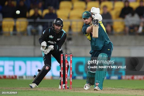 Australia's Tim David plays a shot as New Zealand's wicketkeeper Devon Conway reacts during the first Twenty20 international cricket match between...