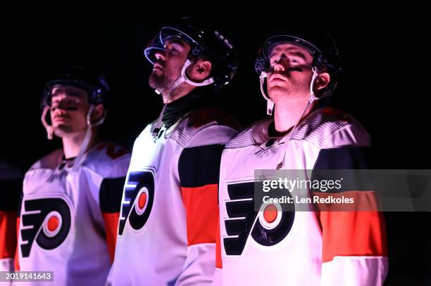 Sean Walker, Ryan Poehling and Cam York of the Philadelphia Flyers line up for pregame ceremonies before the 2024 Navy Federal Credit Union Stadium...