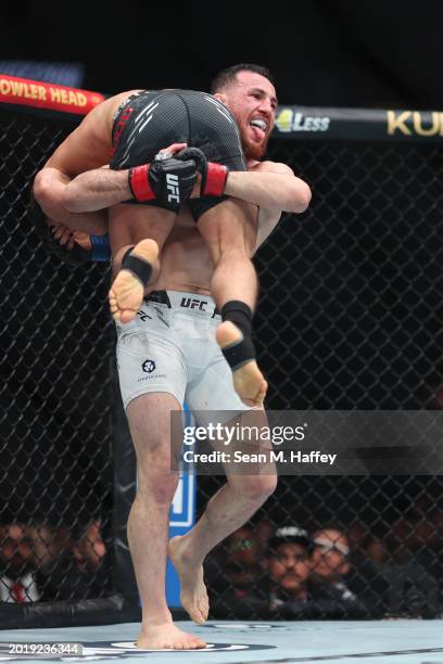 Merab Dvalishvili picks up Henry Cejudo in their bantamweight weight fight during UFC 298 at Honda Center on February 17, 2024 in Anaheim, California.