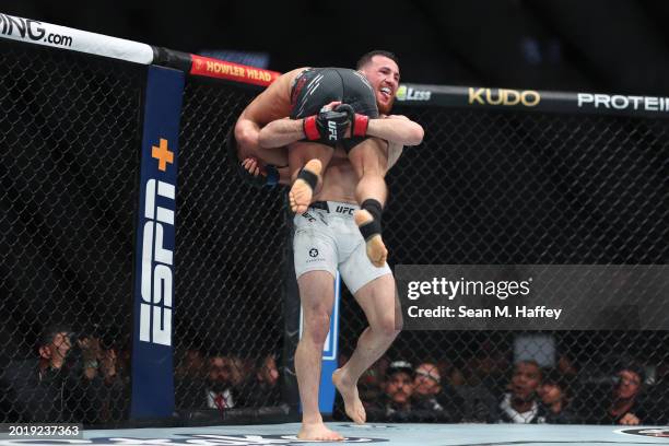 Merab Dvalishvili picks up Henry Cejudo in their bantamweight weight fight during UFC 298 at Honda Center on February 17, 2024 in Anaheim, California.