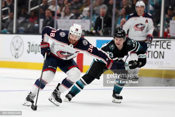 Boone Jenner of the Columbus Blue Jackets skates past Calen Addison of the San Jose Sharks in the first period at SAP Center on February 17, 2024 in...