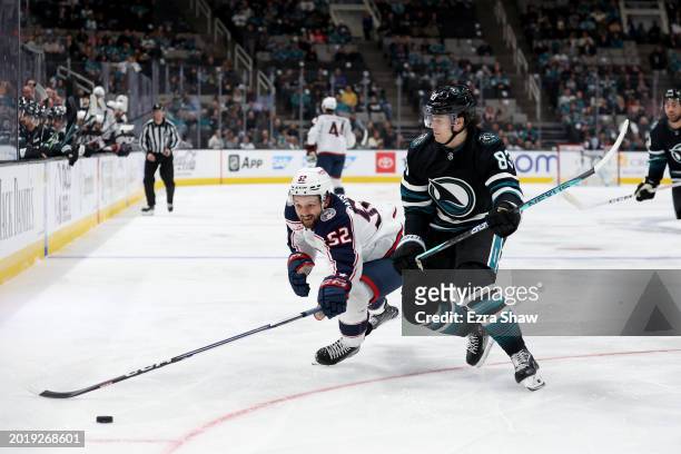 Emil Bemstrom of the Columbus Blue Jackets and Nikita Okhotiuk of the San Jose Sharks go for the puck in the first period at SAP Center on February...