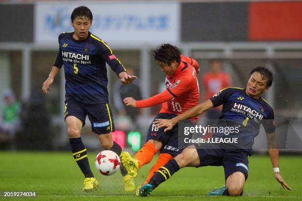 Genki Omae of Omiya Ardija competes for the ball against Yuta Nakayama and Shinnosuke Nakatani of Kashiwa Reysol during the J.League J1 match between...