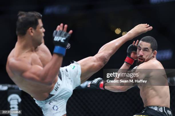 Robert Whittaker of New Zealand evades a kick from Paulo Costa of Brazil in their middleweight fight during UFC 298 at Honda Center on February 17,...