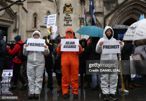 Demonstrators hold placards as they protest outside of the Royal Courts of Justice, Britain's High Court, in central London on February 21 on the...