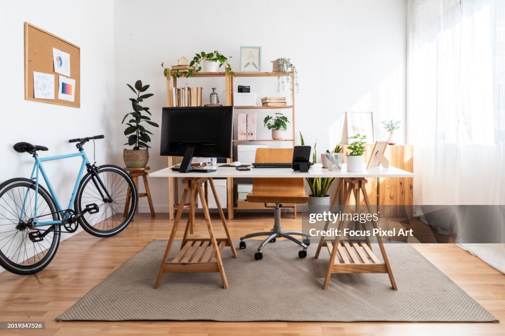 Modern small office in a loft apartment with desk and bicycle