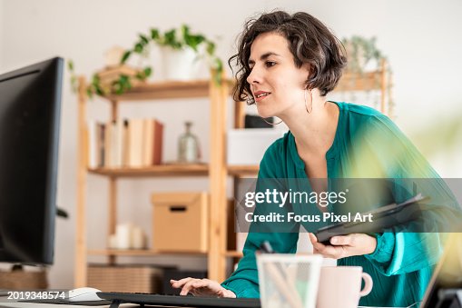 Multitasking woman using computer standing on a modern office Multitasking woman using computer standing on a modern office