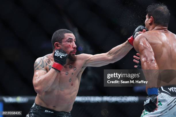 Robert Whittaker of New Zealand punches Paulo Costa of Brazil in their middleweight fight during UFC 298 at Honda Center on February 17, 2024 in...