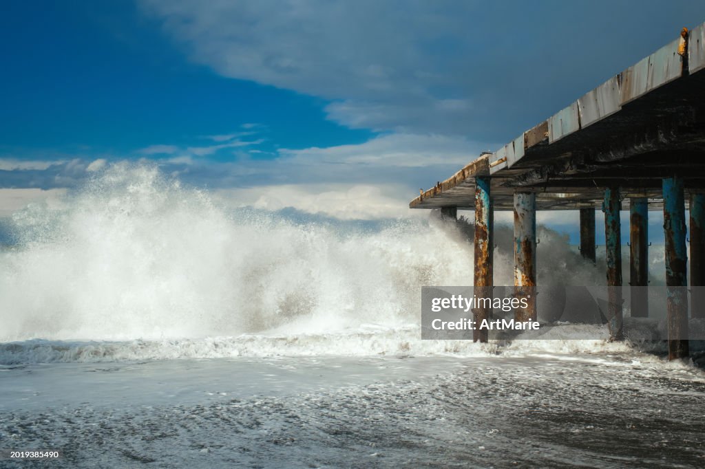 Sea waves breaking a pier in a stormy weather