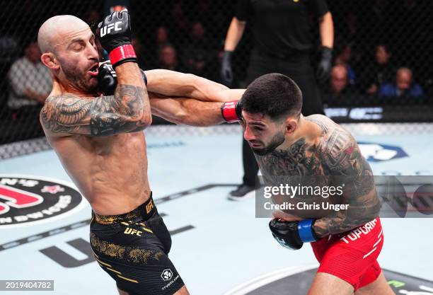 Ilia Topuria of Germany punches Alexander Volkanovski of Australia in the UFC featherweight championship fight during the UFC 298 event at Honda...