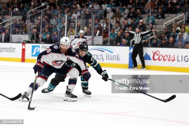 Boone Jenner of the Columbus Blue Jackets skates past Jan Rutta of the San Jose Sharks on his way to scoring the winning goal with 13 seconds left in...