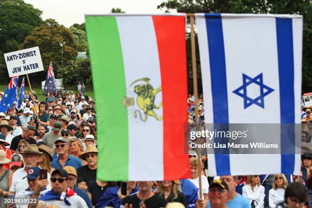 Protestors hold placards and flags during a rally against anti-semitism at The Domain on February 18, 2024 in Sydney, Australia. In response to a...