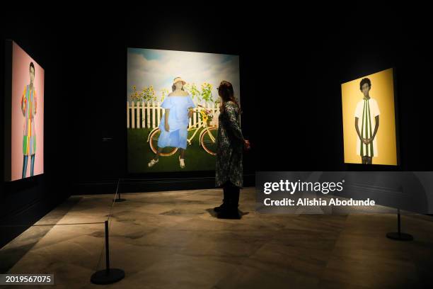 An onlooker admires artwork by Amy Sherald at National Portrait Gallery on February 21, 2024 in London, England. The show brings together 22...