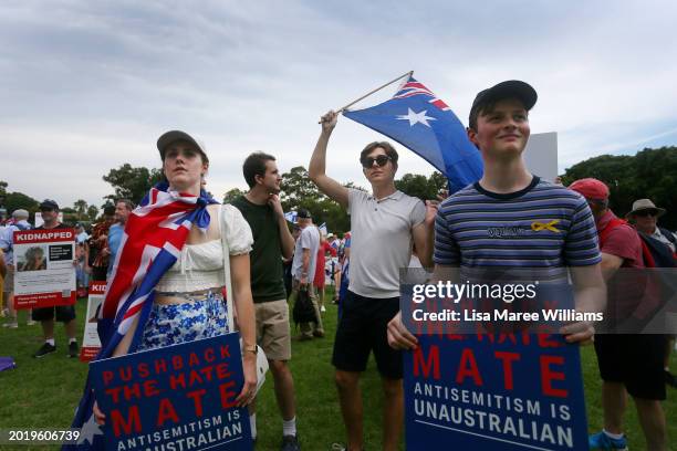 Protestors hold placards and flags during a rally against antisemitism at The Domain on February 18, 2024 in Sydney, Australia. In response to a...