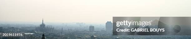 Blanket of smog covers Milan's skyline with the Duomo and the Velasca tower on February 21, 2024 in Milan. Gas-guzzling cars were banned from roads...