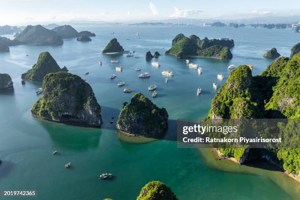 aerial drone sunset scene of tourist ship with rock mountain on the sea at ha long bay, north of vietnam - halong bay stock-fotos und bilder