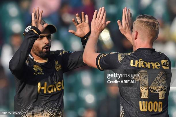Peshawar Zalmi's Luke Wood celebrates with his captain Babar Azam after taking the wicket of Karachi Kings' Shan Masood during the Pakistan Super...