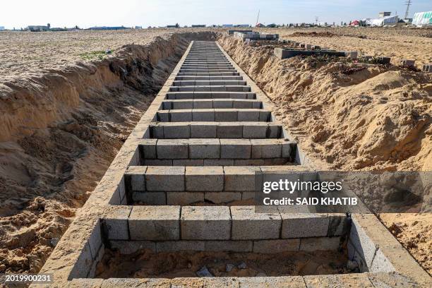 This picture shows graves prepared for the funeral of Palestinians killed in overnight Israeli strikes at a cemetery in Rafah, on the southern Gaza...