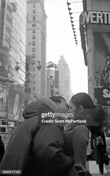 An unidentified man leans in to kiss a woman on Broadway in Times Square, New York, New York, January 5, 2003.