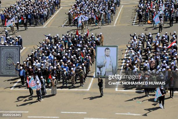 Students recruited into the ranks of Yemen's Huthi stand with supporters next to a portrait of the rebel movement's leader Abdul Malik al-Huthi,...