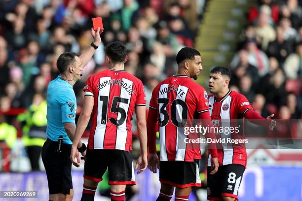 Referee Stuart Attwell shows a red card to Mason Holgate of Sheffield United after a VAR review during the Premier League match between Sheffield...