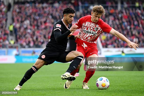 Yannik Keitel of SC Freiburg battles for possession with Omar Marmoush of Eintracht Frankfurt during the Bundesliga match between Sport-Club Freiburg...