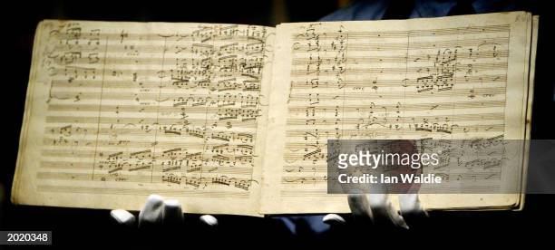 Sotheby's porter holds the manuscript for Ludwig van Beethoven's first edition of the Ninth Symphony as it goes under auction May 22, 2003 in London....