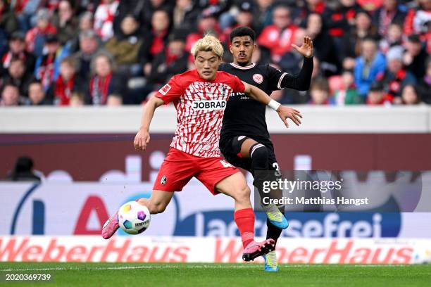 Ritsu Doan of SC Freiburg is challenged by Ansgar Knauff of Eintracht Frankfurt during the Bundesliga match between Sport-Club Freiburg and Eintracht...