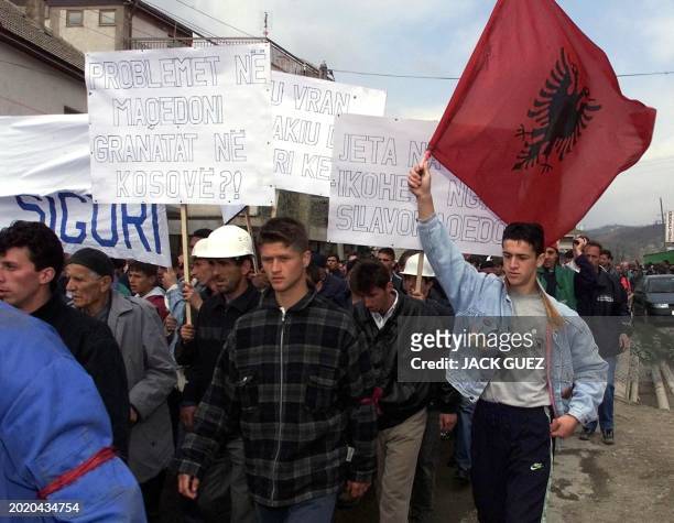 Up to 2000 Kosovo Albanians, holding their national flag, march in the southern Kosovo village of Krivenik 30 March 2001 calling on NATO-led...