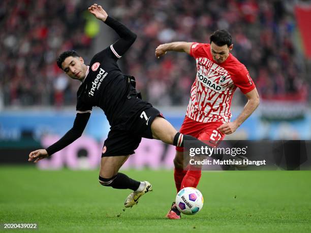 Omar Marmoush of Eintracht Frankfurt is challenged by Nicolas Hoefler of SC Freiburg during the Bundesliga match between Sport-Club Freiburg and...