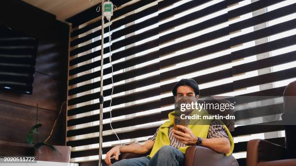 man receiving intravenous vitamin therapy in beauty clinic - electrolyte stock pictures, royalty-free photos & images