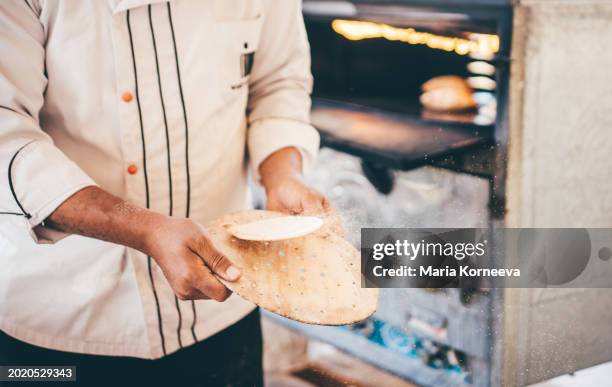 egyptian man baking eesh baladi bread. - middle eastern food stock pictures, royalty-free photos & images
