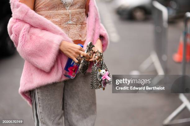 Guest wears Balenciaga sunglasses, earrings, a pearl beaded necklace, floral embroidery mesh top, a pink oversized fluffy faux fur coat, gray denim...