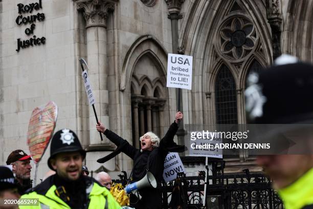 Demonstrator dressed as a judge chants slogans and holds placards during a protest outside of the Royal Courts of Justice, Britain's High Court, in...