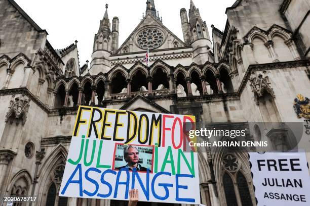 Demonstrator holds a placard reading "Freedom for Julian Assange" during a protest outside of the Royal Courts of Justice, Britain's High Court, in...