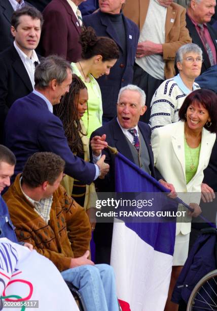 Le membre du CIO et médaillé olympique de ski alpin Jean-Claude Killy plaisante avec le champion olympique de marathon à Melbourne en 1956, Alain...